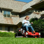 Woman riding on Toro Timecutter in front yard