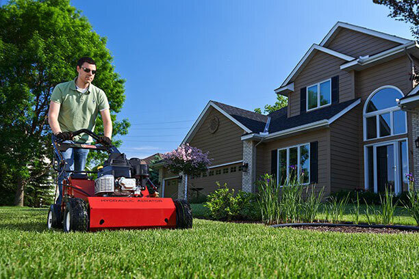 Man using Toro Hydraulic Aerator in front yard