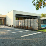 Exterior of modern home featuring stone driveway and landscaping.